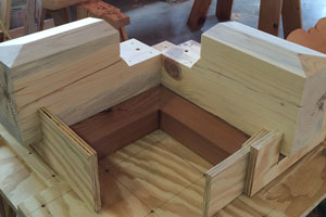 Both redwood bases and both beam extensions inserted into jig to be structurally screwed together as one